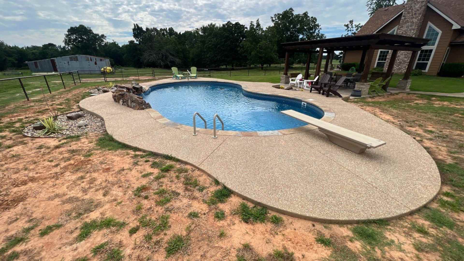 inground vinyl liner pool completion showing waterfall and diving board